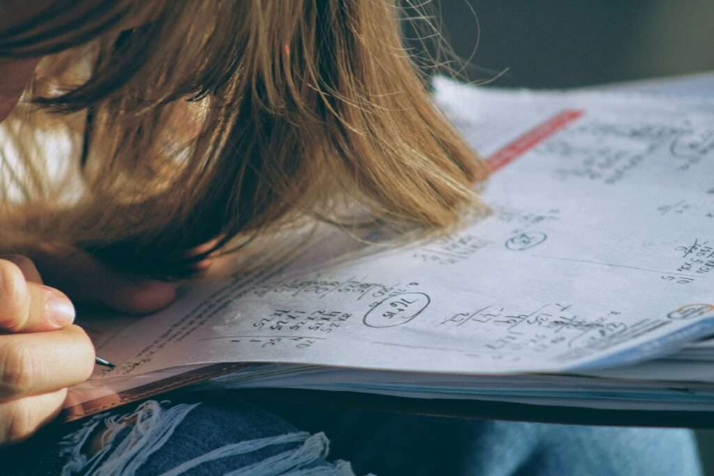 A student sits at a desk, working on math homework.