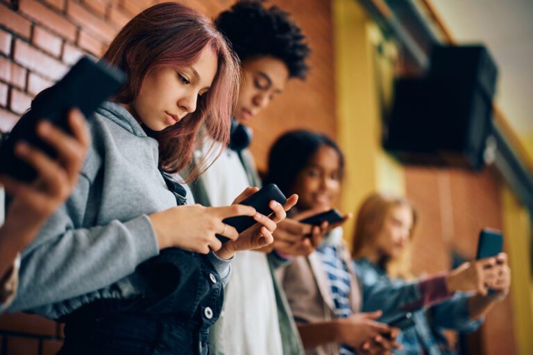 Middle Schoolers and cell phones in a hallway at school.